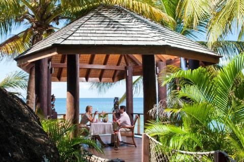 Tropical gazebo dining with couples by the sea, palmy ambiance, sunny day