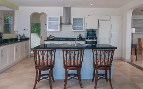 Modern kitchen with island, bar stools, and stainless steel appliances