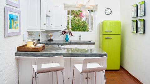 Retro-style kitchen with SMEG fridge and marble island in a bright, inviting space