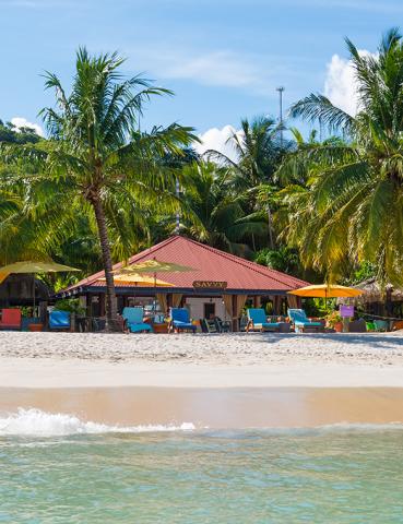 Scenic beach with blue sea, colorful chairs under umbrellas, and 