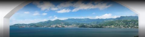 Coastal town view through arch with sea, boats, and lush mountains