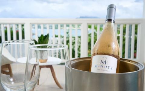 Chilled Minuty rosé wine in bucket with glasses on balcony overlooking coast