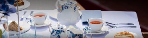 Elegant afternoon tea setup with floral pattern tea set and snacks
