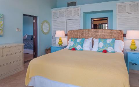 Colorful beach-themed bedroom with blue walls and yellow bedspread.