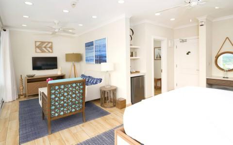 Cozy studio apartment with bed, sofa, kitchenette, and modern decor.