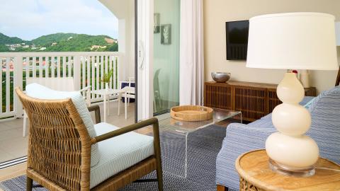 Cozy beach-themed room with balcony overlooking hills, modern decor