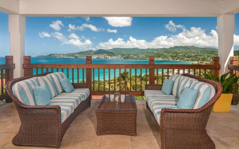 Scenic coastal view from balcony with wicker furniture overlooking bay