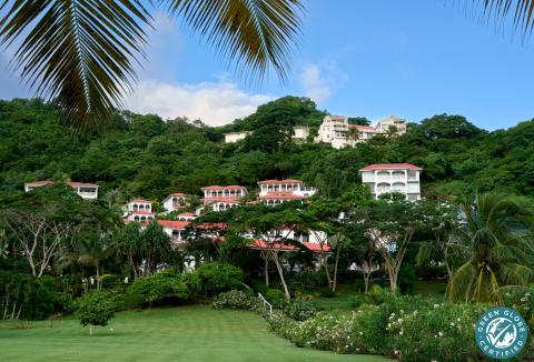 Luxury hillside tropical resort with red-tiled roofs and lush greenery, Green Globe Certified