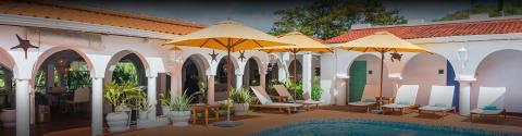 Luxurious resort pool with wooden loungers and yellow umbrellas