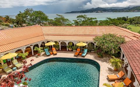 Luxurious poolside with colorful loungers and Mediterranean architecture.