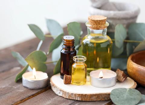 Aromatherapy setup with oils, candles, eucalyptus, and herbal tools