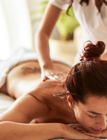 Relaxed woman receiving back massage in serene spa setting