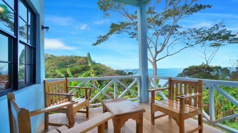 Scenic balcony with wooden furniture overlooking the coast