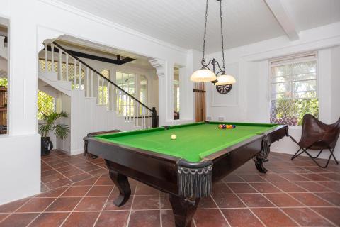 Spacious game room with billiards table, dartboard, and elegant decor