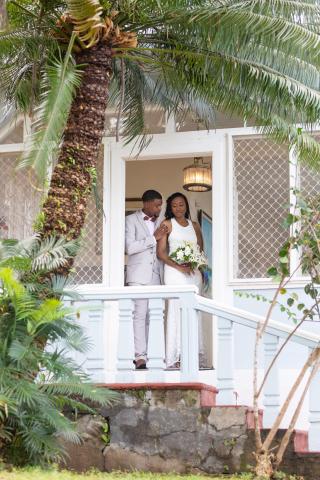 Newlywed couple sharing a moment on a tropical porch.