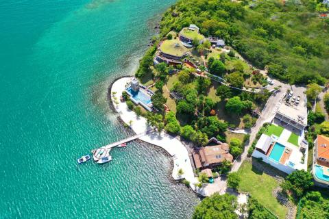Aerial view of a tropical coastal resort with turquoise waters and unique architecture.