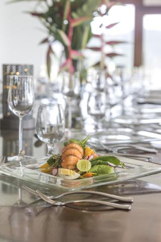 Exquisite lobster tail dish with salad on a decorated dining table.