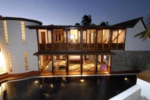 Luxury two-story resort with pool and tropical palm trees
