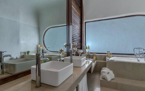 Luxurious double vanity bathroom with modern sinks and marble bathtub.