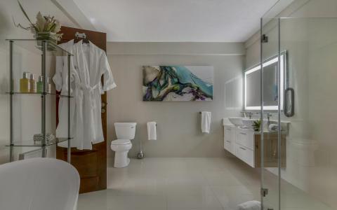 Stylish modern bathroom with freestanding tub, shower, and abstract art.