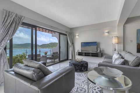 Luxurious living room with sea view, modern decor, and natural lighting.