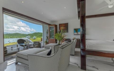 Luxurious open-plan room with houndstooth sofa and scenic bay view