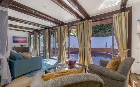 Elegant room with teal couch, grey armchairs, and pool view enhancing the homey ambiance.