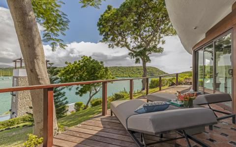 Luxurious waterfront terrace with plush lounger and scenic bay view