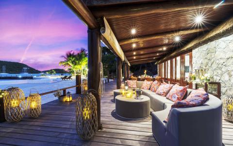 Luxurious outdoor seating area with sofas and harbor view at dusk.