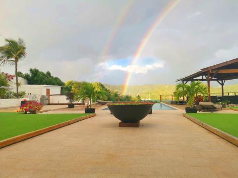 Luxurious mountain view property with infinity pool and double rainbow.
