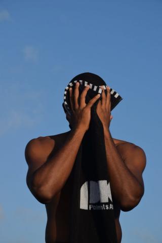 The image features a person standing against a clear blue sky