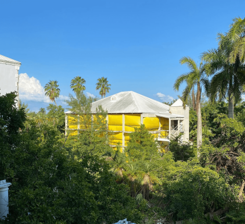 The image shows a building that appears to be under construction or renovation, as part of it is covered with bright yellow scaffolding