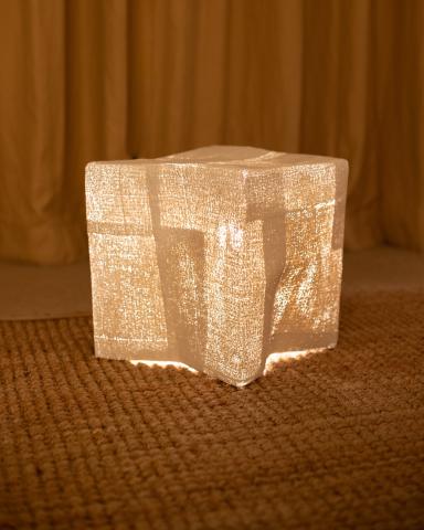 The image displays a cube-shaped object illuminated from within, casting a soft, glowing light