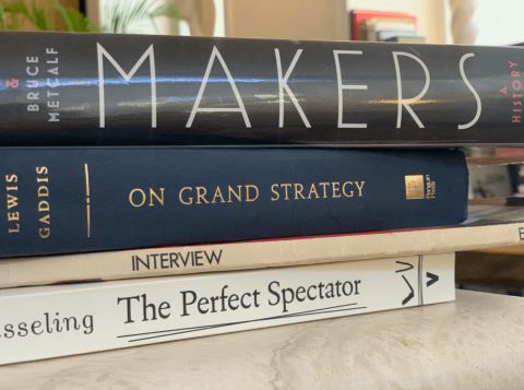 The image shows a stack of four books