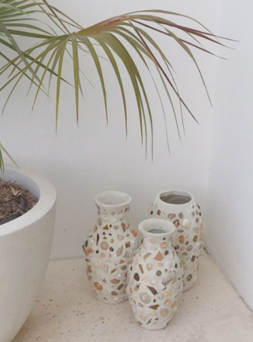 This image shows three decorative vases with a pierced or lattice design, displaying a motif that includes circular and organic shapes