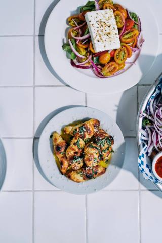 The image shows two plates of food on white tiled surface