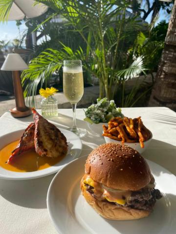 The image features a meal set outdoors amid lush greenery, presumably in a tropical setting based on the flora visible