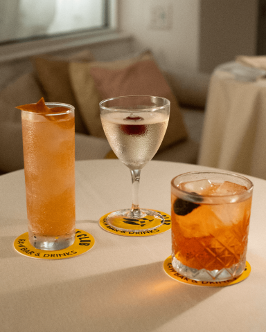 This image shows three different cocktails placed on a table, each with a unique presentation:

1