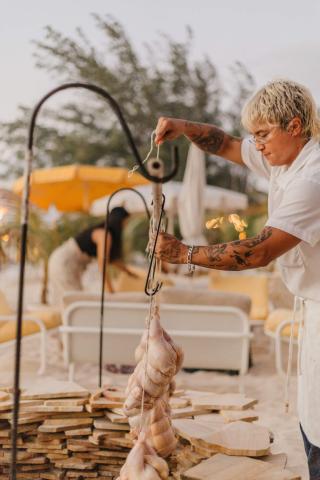 This image features a person outdoors, likely preparing food at an event or a dining establishment