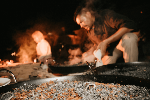 This image captures a dynamic nighttime scene of outdoor cooking