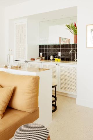 This image shows a well-decorated interior space featuring a view from a living area into a kitchen