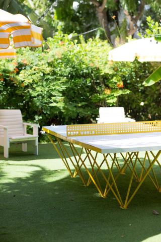 The image shows an outdoor setting with stylish furniture on a lush green artificial grass surface