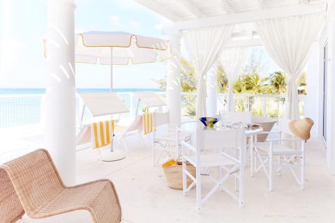 This image captures a serene and elegant beachfront patio setting