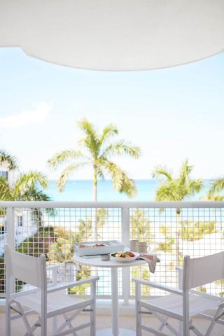 This image shows a serene balcony setup overlooking a tropical beach view