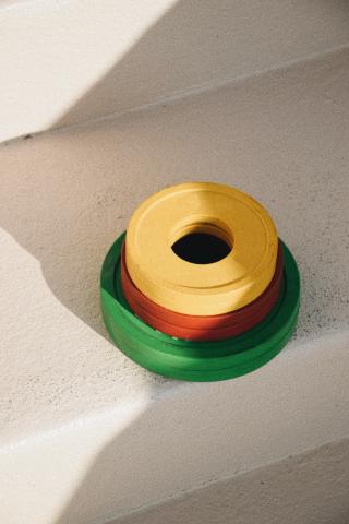 The image shows a set of colorful plastic rings stacked on a stair step