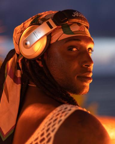 This image features a close-up of a man wearing headphones