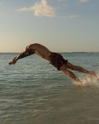This image captures a dynamic moment of a person diving into the water