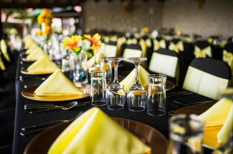 Elegant banquet table with black and yellow theme, sunflowers.