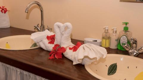 Decorative bathroom vanity with painted basin and artistic towel display.