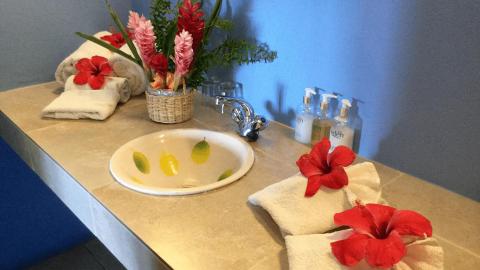 Bathroom vanity with sink, decorative citrus slices, and spa-like towels.